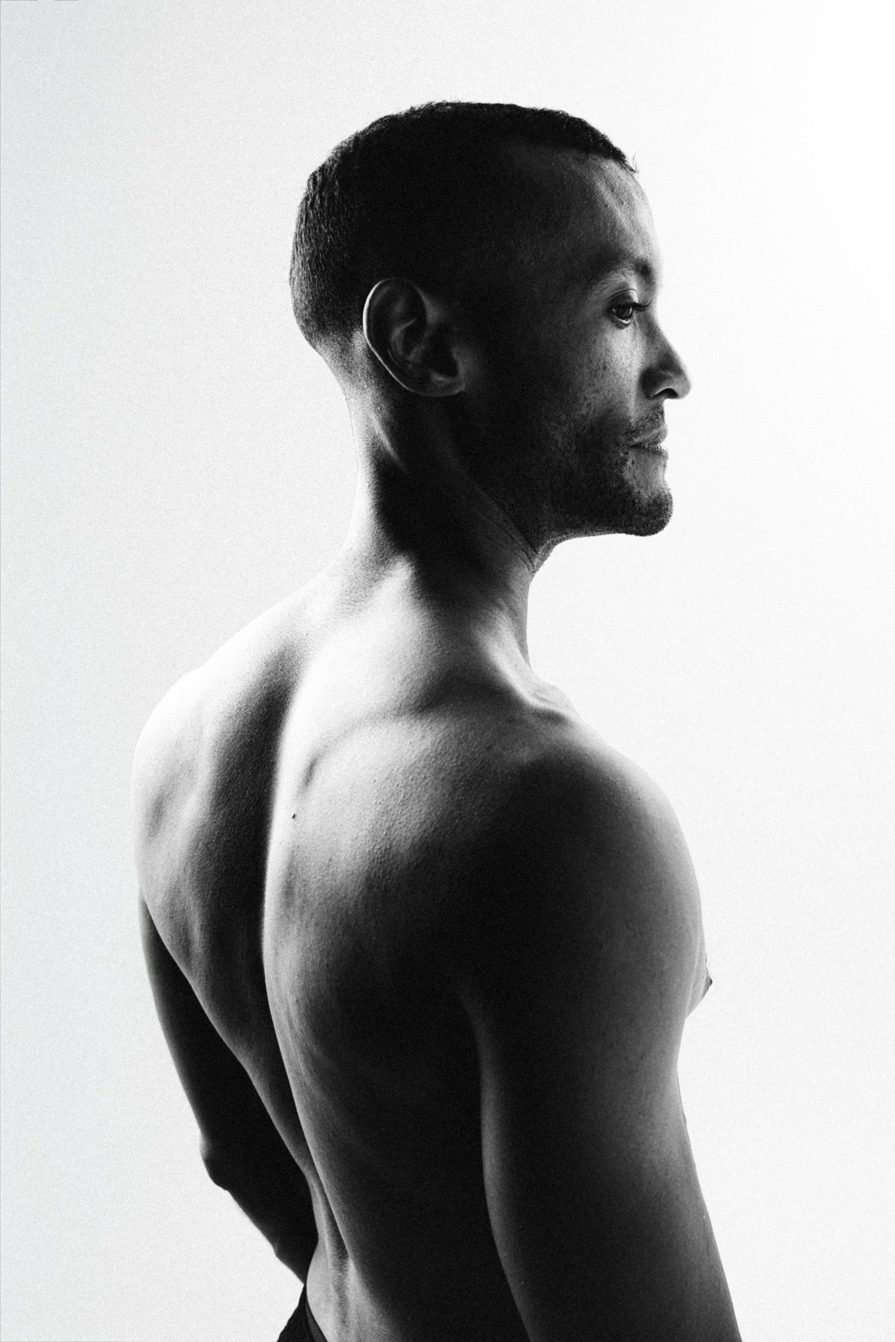 Bare-shouldered profile of David against a bright white background