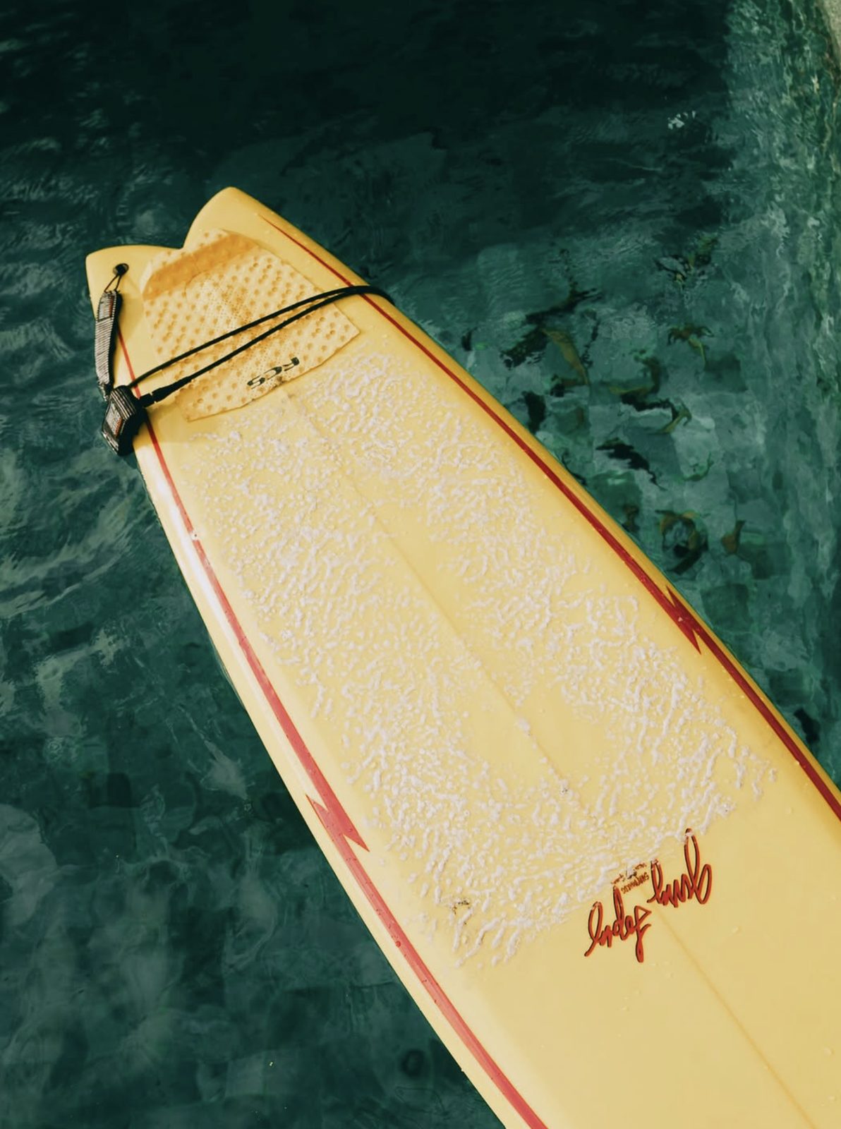 Yellow surfboard floating in the villa pool